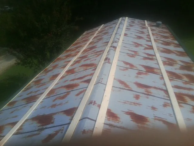 Rusted metal roof panels with new wood purlins before replacement — Storm Damage Roof Repair in Chesterton by Roofing Brothers