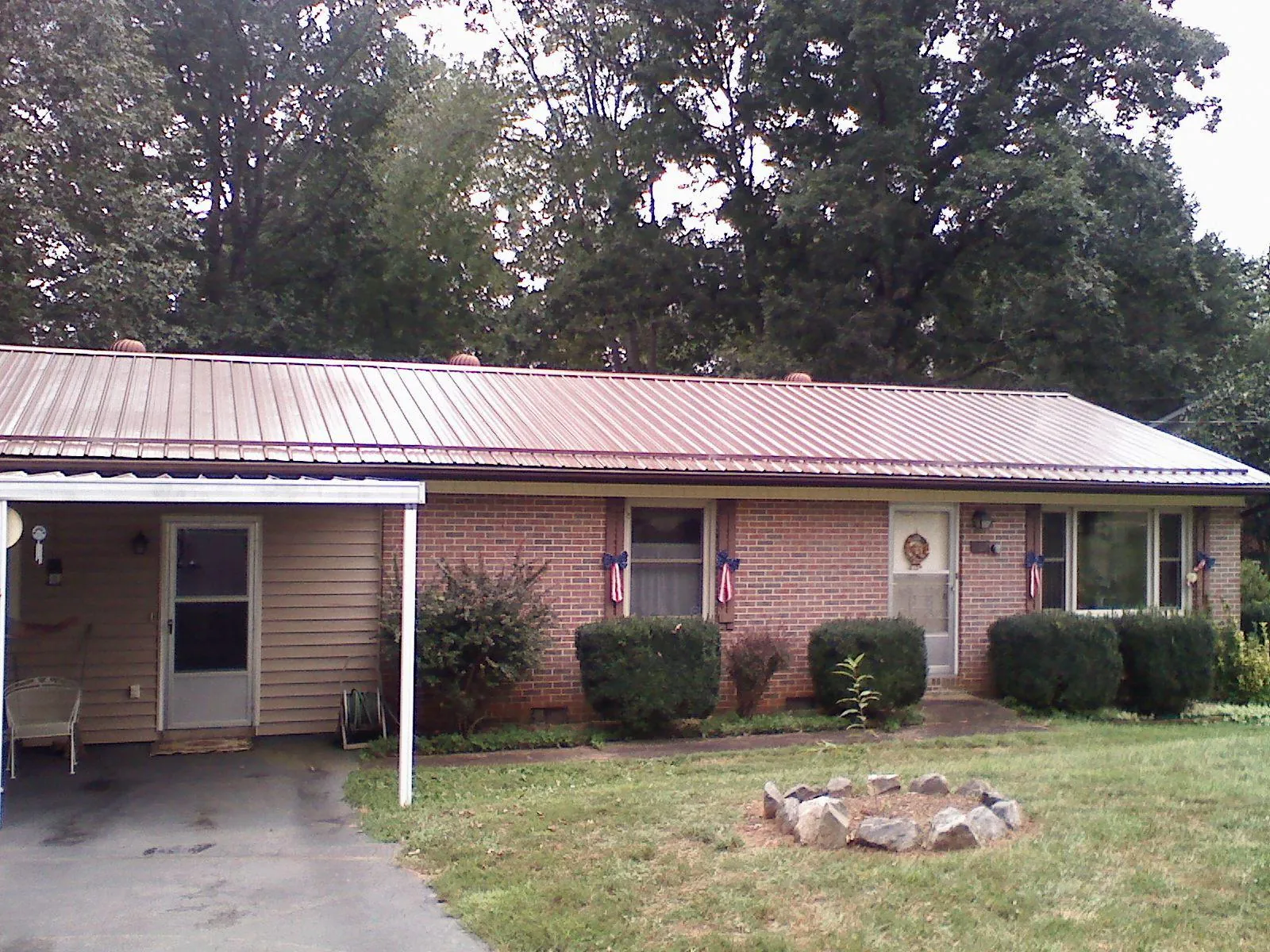 Bronze metal roof and carport on a brick ranch home — Roof Repair work by our crew in Chesterton